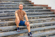© Iurii Gagarin - Caucasian male adult sitting on steps outdoors in casual attire