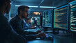© Arslan - Software developers working on code on multiple computer monitors in a dark modern office
