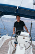 © Nazareno - Mature man steering sailing boat on open sea