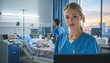 © AULIA - A medical professional in blue scrubs smiles in a hospital room, caring for patients with equipment