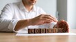 © Oye - A professional man in a white shirt arranges wooden blocks spelling the word lobbying carefully today.