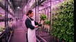 © Guzel - Female worker checking lettuce roots on a vertical hydroponic rack under pink LED lights holding a digital tablet. Smart farming, sustainable agriculture, indoor food production.
