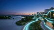 © kitti - Future smart eco city concept with glowing blue light lines wind turbines and solar farm at twilight.
