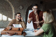 © Novak - Small startup business team working together at office desk