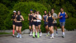 © master1305 - Large running club jogging together on sunny park path. Concept of marathon training, group cardio exercise, community fitness, healthy habits, endurance and active urban lifestyle.