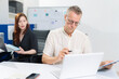 © NINENII - Caucasian business team working at office with laptop and documents on desk, financial adviser analyzing data.