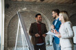 © Novak - Three diverse business people brainstorming and looking at whiteboard