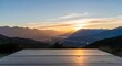 © Doly - A serene mountainous landscape at sunset with a wooden platform