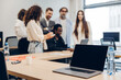 © Maria Vitkovska - Business team collaborating in an open-plan office setting selective focus on laptop