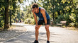 © Arra Vais - Exhausted male runner recovering from heat stress after training on a hot summer day. Tired athlete with sweat soaked shirt resting on a park path. Outdoor fitness and extreme weather concept