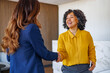 © PeopleVideos - Professional businesswomen shaking hands in office representing successful partnership and business agreement