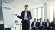 © SashaMagic - Confident businesswoman presenting an action plan on a flipchart to seated colleagues in a modern office