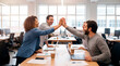 © Rendara Studio - Business team celebrating success with high five at desk in bright modern office
