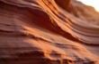 © Maryna - Close-up view of wavy red rock formations with layered patterns. Warm sunlight illuminates stone curves, highlighting natural erosion and fine granular texture in desert landscape.