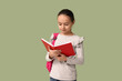 © Pixel-Shot - Little schoolgirl reading book on green background