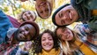 © Selvi - Diverse group of friends smiling and laughing while gathered in a circle outdoors during autumn