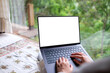 © Farknot Architect - Mockup image of a woman working and typing on laptop computer with blank desktop white screen on the bed at home