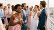 © Hello Stock - Diverse group of friends laughing and drinking at an outdoor wedding reception party at sunset