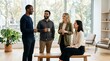 © Alva - Four diverse business professionals having a casual conversation and coffee break in a modern, sunlit office space.