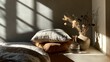 © Btni - Sunlight creates dramatic shadows across a wall and pillows next to a glass carafe and a vase of dried flowers.
