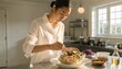 © Shahzad - A person in a white shirt tosses a grain salad with vegetables in a bright kitchen, suited for healthy eating, meal prep, and home cooking promotions.