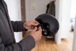 © Debi Kurnia Putra - Man fastening chin strap on black bicycle helmet