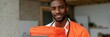 © Iryna - Young male clinician carrying orange medical bag and laptop for mobile clinic banner and oncall healthcare background