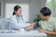 © amnaj - Doctor checking patient blood pressure during health examination
