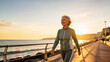 © lifestyle27 - AI Generated Senior Woman Jogging and Walking in Tracksuits on Coastal Boardwalk at Sunset
