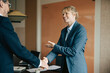 © Maskot - Happy female executive shaking hands with male colleague after successful meeting