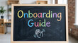 © Rodrigo - 'Onboarding Guide' written in colorful chalk on a blackboard in a bright office setting