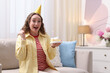 © New Africa - Woman holding piece of cake with burning candle indoors. Space for text