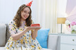 © New Africa - Woman holding piece of cake with burning candle indoors. Space for text