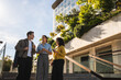 © pablo - Three business colleagues standing outdoors, having coffee, and discussing during a break