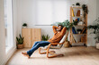 © Westend61 - Happy man relaxing on armchair at home