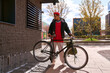 © LIGHTFIELD STUDIOS - Handsome young man in stylish attire enjoys the city with his bicycle under a bright sky