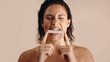 © Jacob Lund - Woman biting unbranded lip balm in minimalist studio shoot