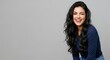 © Network Stock - Young beautiful woman with long dark wavy hair winking and laughing against a light grey studio background