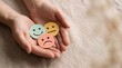 © Nusrat - Pair of hands holding three circular paper cutouts with colorful smiley neutral and sad emoji faces representing customer feedback satisfaction levels on neutral beige linen background.