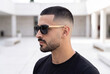 © Mustafa Kawa - Side profile of a stylish man with a buzz cut fade and beard wearing wooden sunglasses