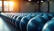 © miss irine - Rows of blue fitness balls in bright gym hall with sun rays. Equipment for exercise and training. Stability balls ready for active workout session.