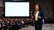 © Azorahaiá - Confident businesswoman presenting to an engaged audience in a modern conference hall with a large blank screen