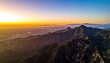 © Hasrul - Aerial view of a sprawling city at sunset from a mountainous vantage point.