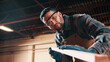 © peopleimages.com - Carpentry, sanding or man in factory with wood, fabrication or quality control in furniture production. Below, ppe or carpenter with plank, timber polishing or manufacturing process in woodworking.