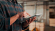 © peopleimages.com - Hands, tablet and scroll in carpentry factory, check lumber order or online inventory management. Person, carpenter and tech for digital stock analysis or search woodworking merchandise app for info