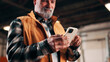 © peopleimages.com - Carpentry, hands and phone with man in factory for management of agenda or schedule. App, manufacturing and production feedback with mature person in woodworking warehouse for furniture business