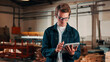 © peopleimages.com - Carpentry, happy and man on tablet in workshop for planning, schedule or manufacturing quote. Warehouse, male person or carpenter with technology for woodwork or furniture production with smile