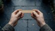 © Ahmdfadhilah - Person Holding Wooden Ruler Measuring Small Distance Outdoors Showing Precision Measurement Concept With Close Up View Of Hands Positioning Measuring Tool Over Dark Stone Pavement Background