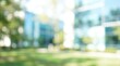 © joharia - Blurred outdoor background of a modern office building with green lawn on a sunny day.