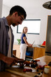 © Adrian Rodd/Stocksy - A blonde woman and a man prep food in a bright, modern kitchen.